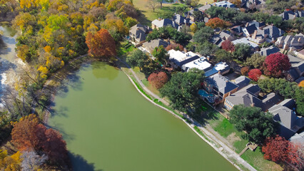 Lakeside house surrounding colorful fall foliage and White Rock Creek in Park Central, North Dallas, Texas, upscale waterfront suburban residential homes mature trees, upper class neighborhood