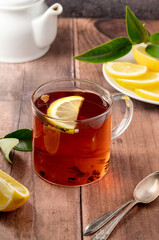 Black tea in glass cup on wooden table 