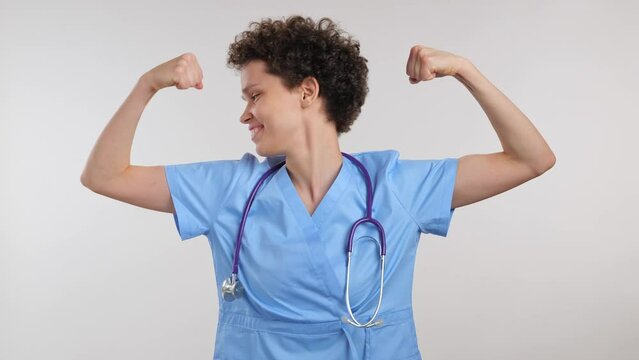 young curly female doctor showing strong hands muscle