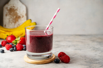 Glass of berry smoothie in a glass. Strawberry, banana, blueberry healthy drink. 