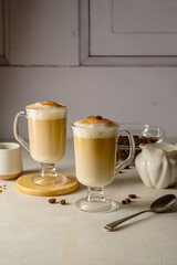 Two cups with coffee drink, latte or mocha with milk foam and cinnamon