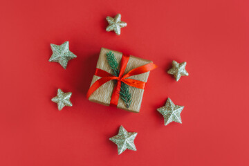 Gift box with Christmas ornaments on a red background. Holiday concept.