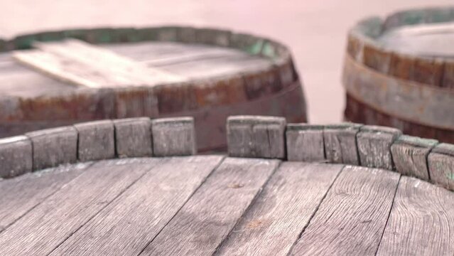 Close-up of old barrels with rusty rims standing on the street. Bondar craftsmanship and winemaking of the last century