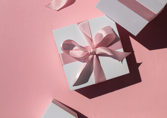 White gift boxes on the pink background. Top view. Copy space