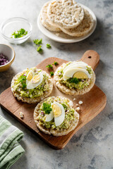 Avocado tuna salad on rice cakes with red onions and boiled egg. 