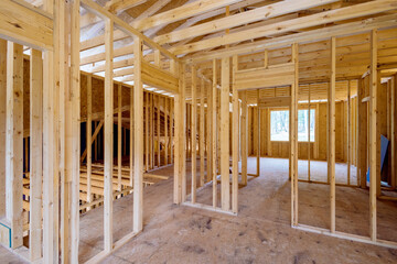 View interior of new house under construction showing incomplete wood framing beams