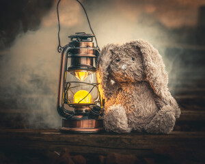 Stoff Hase sitzt neben einer Lampe