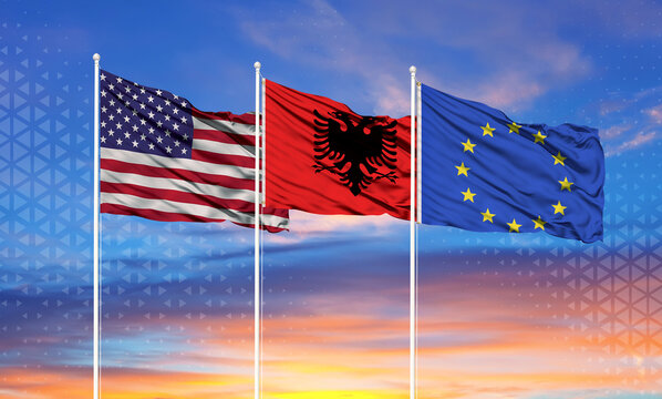 flags of European Union, United States and Albania on flagpoles and blue sky