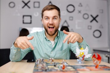Man with board game piece while practicing strategy in home alone. A man plays a board game with...