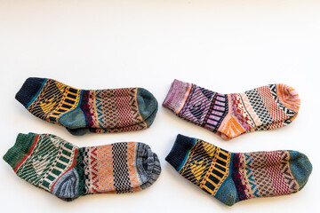 Four pairs of colourful Winter woollen socks of various patterns isolated in a white background.