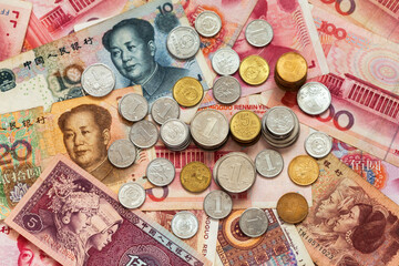 Yuan coins on heap of yuan paper money. Chinese economy and finance concept. Currency background. Trade relations of countries,.inflation, investment, business and lending. Flat lay, close-up