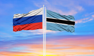 Russia and Botswana two flags on flagpoles and blue sky.