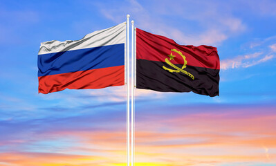 Russia and angola two flags on flagpoles and blue sky.