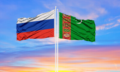 Russia and Turkmenistan two flags on flagpoles and blue sky.