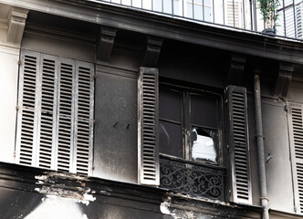 Parisian building exterior after fire. Burnt charred wall. Paris, France. Real estate insurance importance concept.