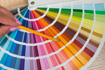 Graphic designer choosing color from sampler
