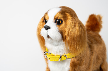 A beautiful children's toy dog of the spaniel breed on a white background.