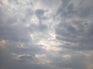 The sun hides in back of broken gray clouds