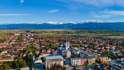 Aerial stunning view of a historic town, surrounded by the picturesque Fagaras mountains - obrazy, fototapety, plakaty