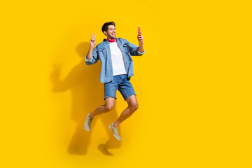 Full body photo of good mood man dressed denim shirt flying make selfie on smartphone show v-sign...