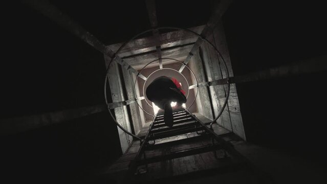 Slow motion low angle footage of a man climbing a vertical staircase with industrial parapets