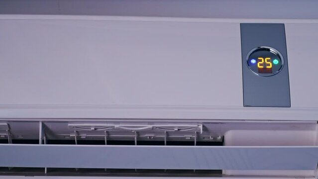 Switch air conditioning mode to blow cool air in the office changing the room temperature. Split system remote control mode change on display. Air conditioner working on a hot summer day