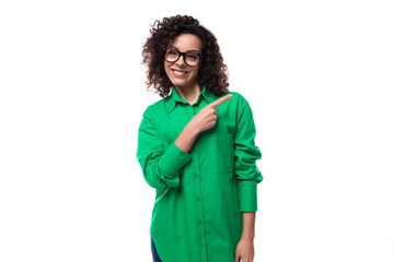 confident smart young business woman dressed in a green shirt points her finger to the side. advertising concept