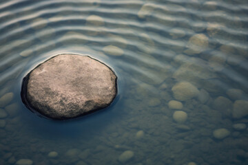 Large round stone in a rocky creek surrounded by water top view. - Powered by Adobe