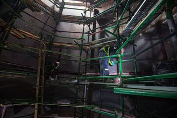 Male climb the stairway scaffolding inspection tank