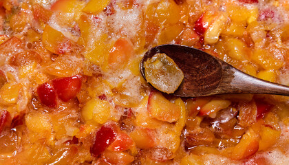 Freshly chopped apples are sprinkled with white sugar and made into apple jam, stirring with a...