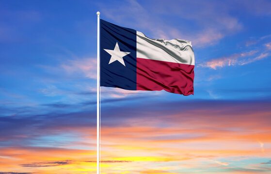  Texas flag on flagpoles and blue sky.