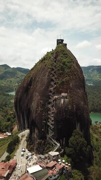 Aerial drone footage of El Penon de Guatape near Medellin in Antioquia, Colombia. Large and unique alone rock with stairs to the top, touristic place. Big stone in Colombia. High quality 4k footage.