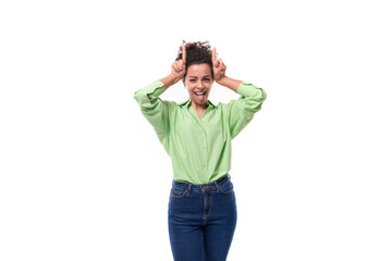 portrait of a young charming brunette businesswoman with curly hair gathered in a bun dressed in an office light green shirt on a white background with copy space