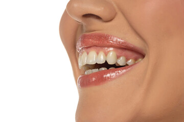 Close-up, side view of a woman's mouth, capturing a confident smile and perfect natural teeth and lips on white background