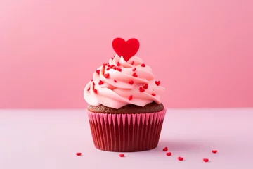 Tuinposter Chocolate muffin (cake) decorated with cream and a red  heart for Valentine's Day on a pink background © NadezhdaShestera