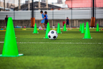Soccer ball tactics cone on grass field with for training background
