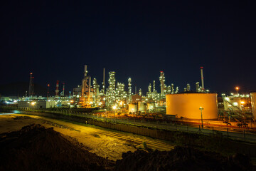 Fototapeta premium Night scene of oil refinery plant and storage white tank oil of Petrochemistry industry