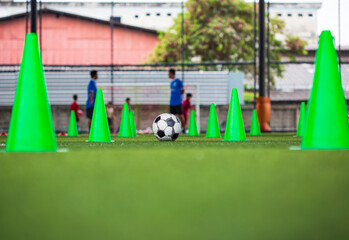 Obraz premium Soccer ball tactics cone on grass field with for training background