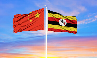 Flag of China and Uganda waving in the wind against white cloudy blue sky together. Diplomacy concept, international relations