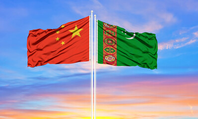 Flag of China and Turkmenistan waving in the wind against white cloudy blue sky together. Diplomacy concept, international relations