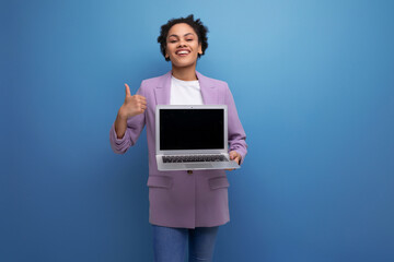 young successful latin woman with afro hair dressed in a jacket holds a laptop to work with a mockup