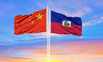 Flag of China and Haiti waving in the wind against white cloudy blue sky together. Diplomacy concept, international relations