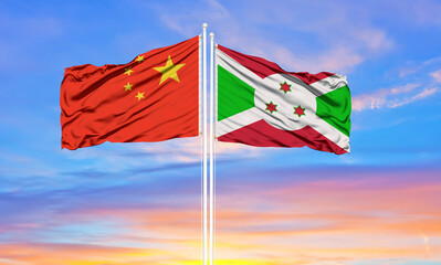 Flag of China and Burundi waving in the wind against white cloudy blue sky together. Diplomacy concept, international relations