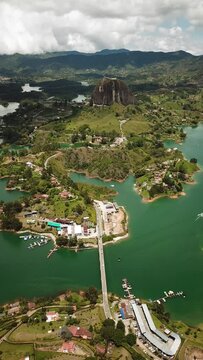 Aerial drone footage of El Penon de Guatape near Medellin in Antioquia, Colombia. Large and unique alone rock with stairs to the top, touristic place. Big stone in Colombia. High quality 4k footage.