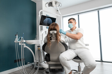 The dentist carefully analyzes the condition of the patient's teeth and oral cavity. The medical center provides modern and safe dental treatment for its patients. The dental clinic helps patients - obrazy, fototapety, plakaty