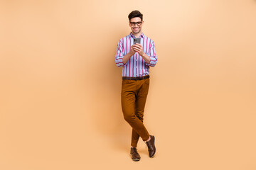 Photo of handsome cheerful man wear striped stylish clothes writing telegram twitter post sms...
