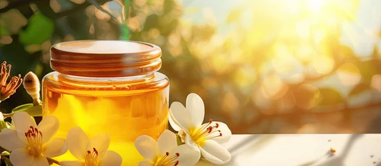 Gordijnen Honey spa treatment Pouring sweet golden honey to jar plumeria flowers soft sunny light Natural homemade skincare. Website header. Creative Banner. Copyspace image © HN Works