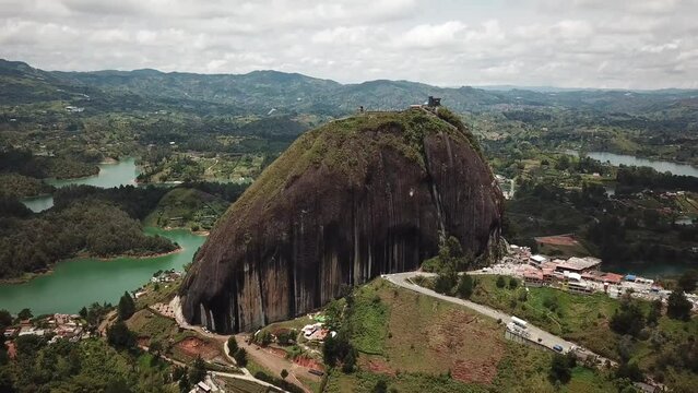 Aerial drone footage of El Penon de Guatape near Medellin in Antioquia, Colombia. Large and unique alone rock with stairs to the top, touristic place. Big stone in Colombia. High quality 4k footage.