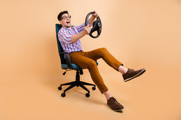Full length photo of crazy cheerful guy sitting chair having fun free time looking empty space...