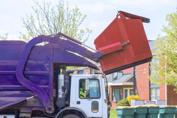 Recycling garbage collector truck loading waste into trash bins for municipal sanitation disposal...
